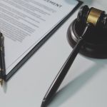 młotek sędziowski obok wniosku do sądu